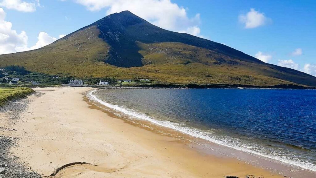 Achill Island gold sandy beach with imposing pointy mountain in background. 