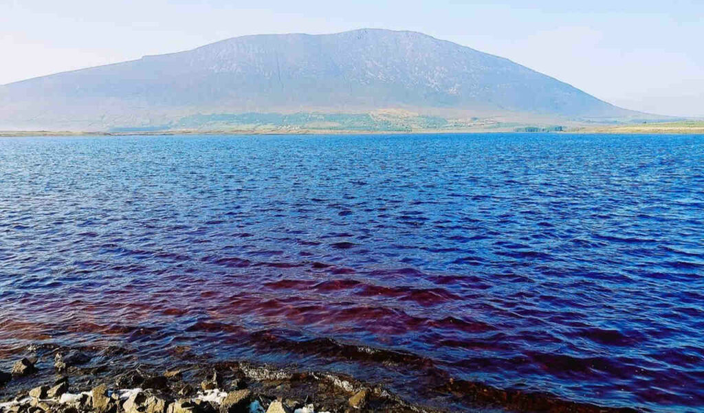 Achill Island scenery, blue sea water in foreground, hazy mountain in background