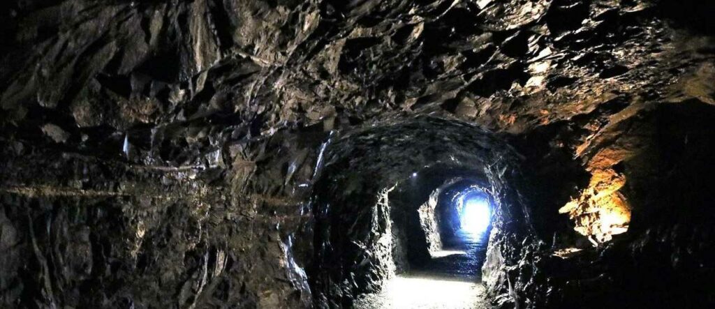 Tunnel in Aillwee Cave, lit rock formations on either side