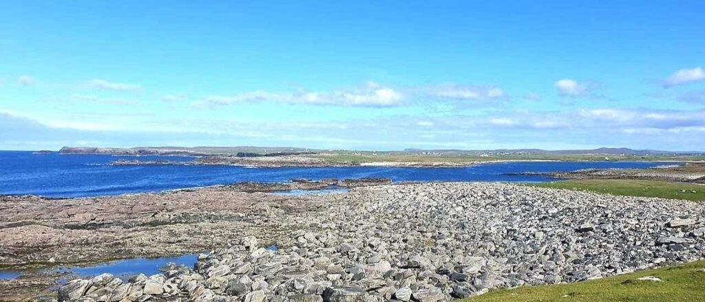 Annagh Head on Mullet Peninsula bedrock, grey stones and blue sea in background