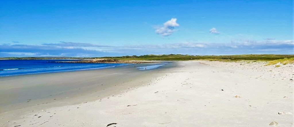 Belderra Strand on Mullet Peninsula, view across the sand towards blue sea and grassy dunes