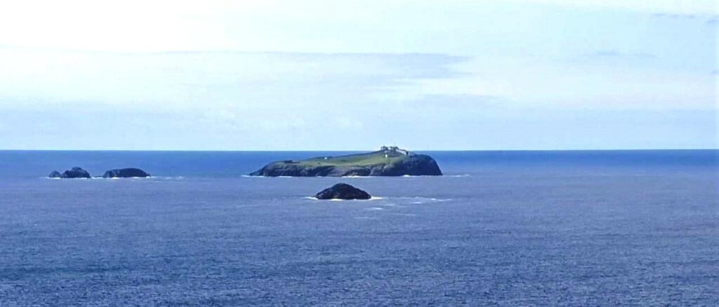 View from Erris Head Loop Walk of Eagle Island, in distance in the sea, some visible white buildings on the island