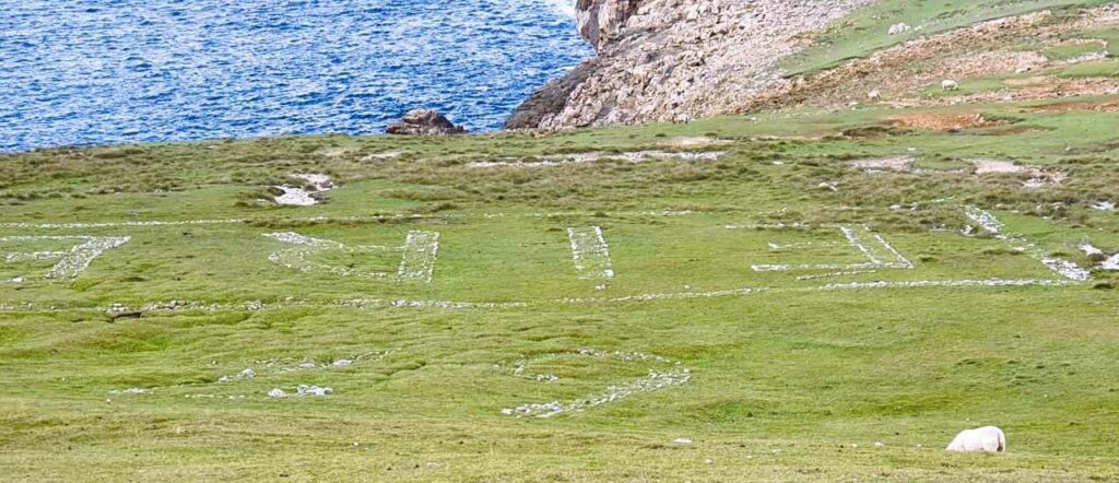 Erris Head Eire 62 sign - white stones making out the letters and numbers in a grassy hillside