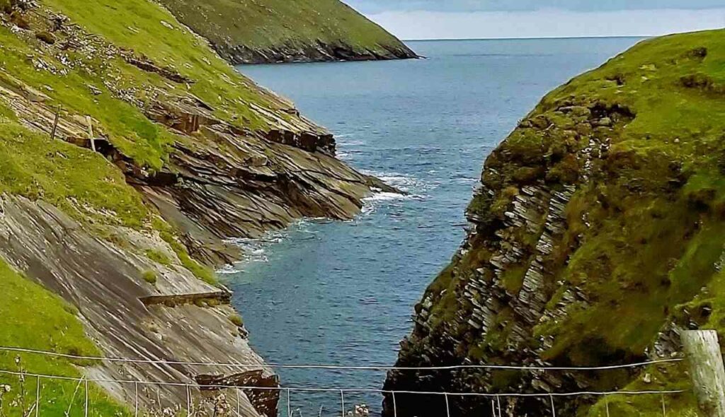 view of the danish cellar on the erris head loop walk, deep sea inlet with steep rocky sides