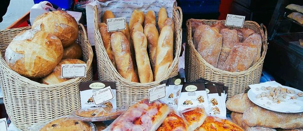 Bakery stall at a farmers market, food festival, round bread, cakes, baguettes in wicker baskets