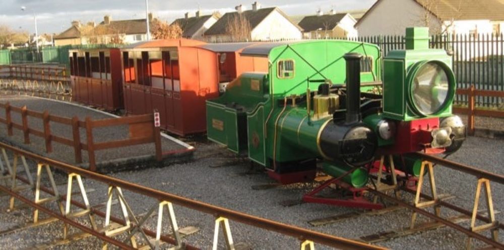 lartigue monorail - green engine and brown carriages up on tracks in listowel