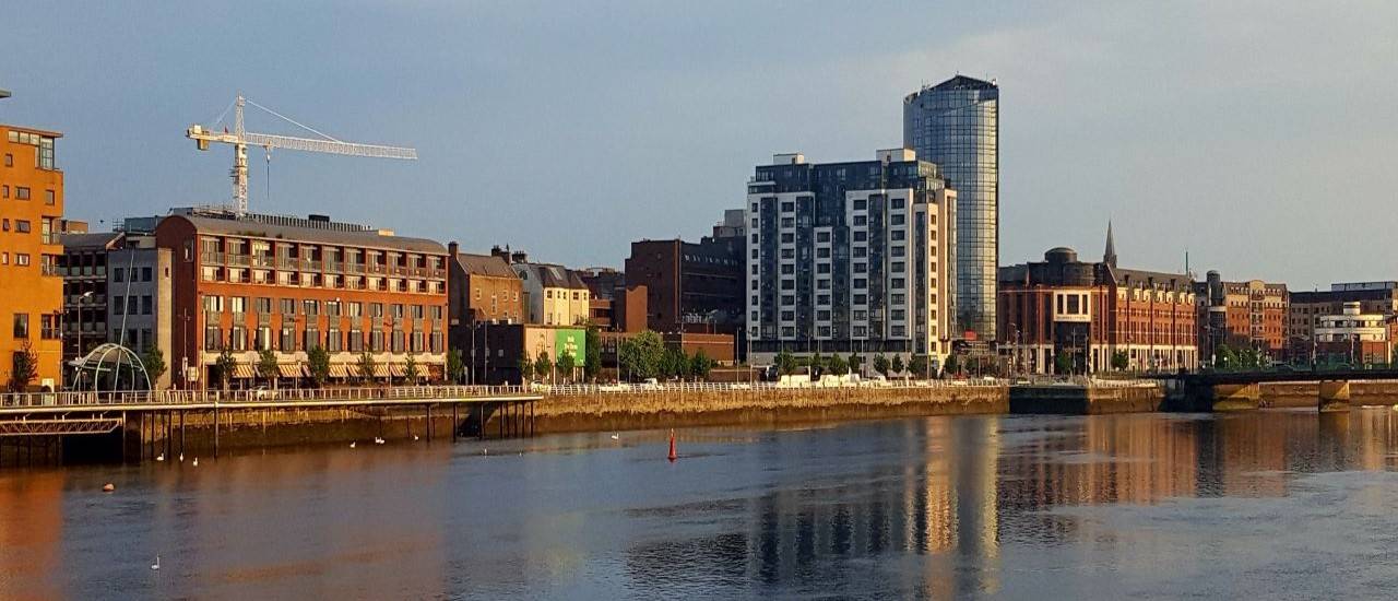 view of limerick city from the river shannon, tall buildings and cityscape