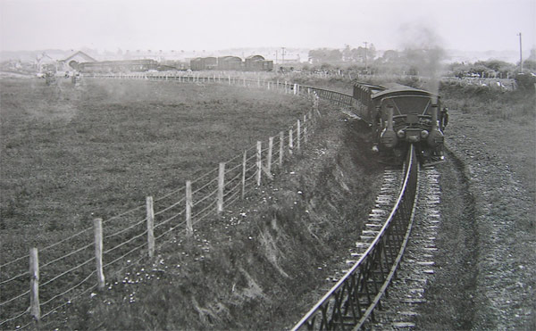 black and white period photo of the lartique monorail running across fields towards camera