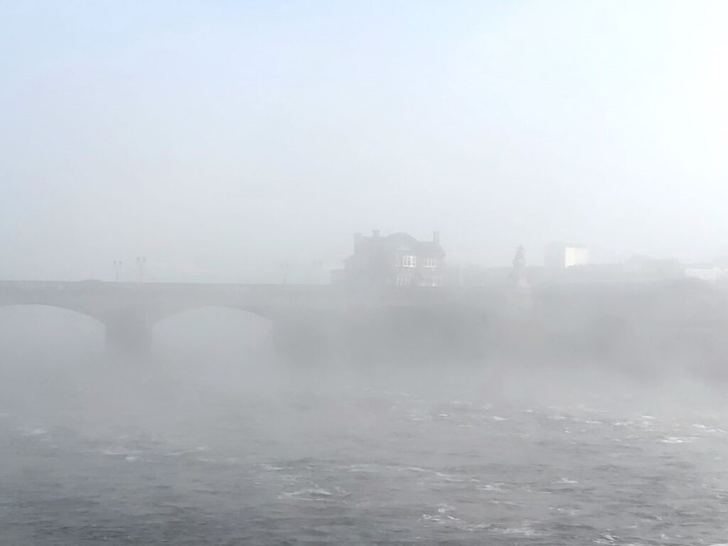 view of winter fog rolling over the river Shannon and Sarsfield Bridge in Limerick City