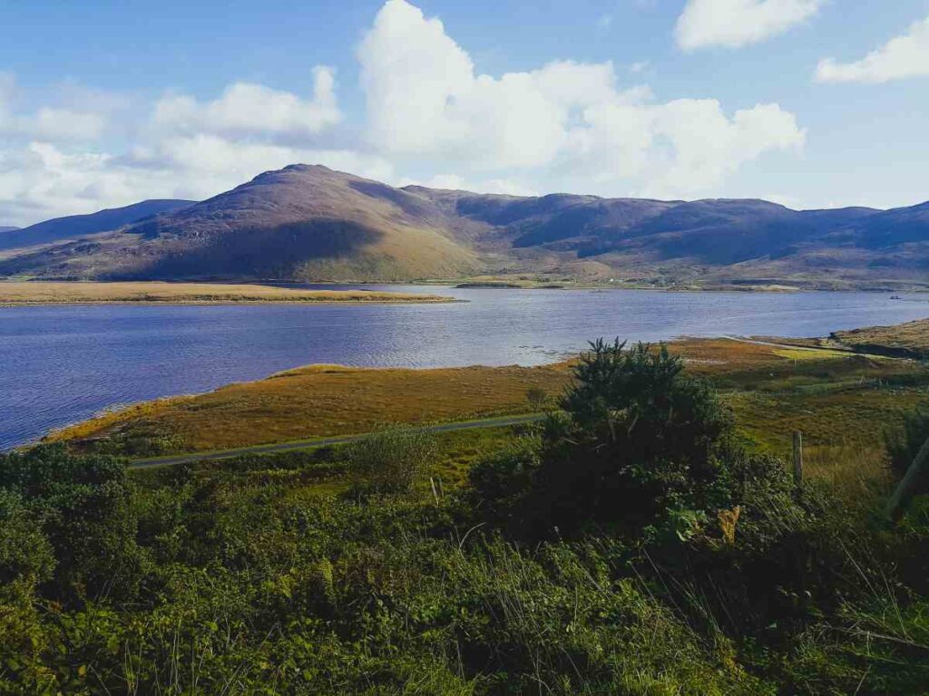 View from the shore of Achill Islan, County mayo in the West of Ireland,  in the foreground across a sea inlet onto  a mountain rising on the other side of the inlet. 