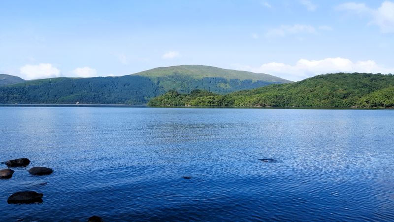 View of calm Loch Lomond on the west highland way, blue water with green gentle hills rising in the background