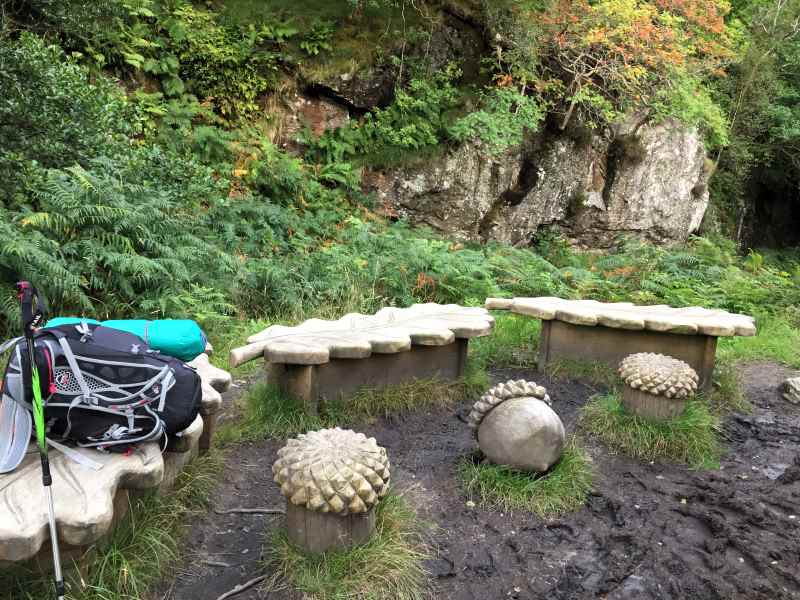 Wooden rest near Doune Bothy on West Highaland Way in Scotland - carved tables and seats in the shape of acorns