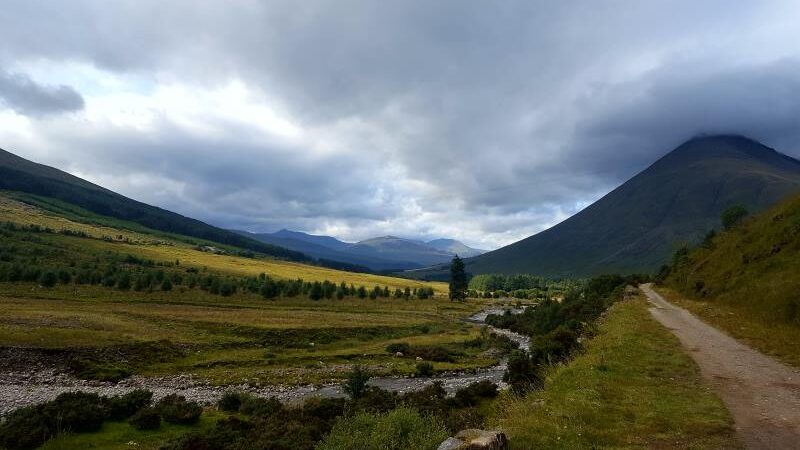 View of the trail from Tyndrum to Bridge of Orchy on the West HIghland Way, scenery with rolling hills and a small river to the left